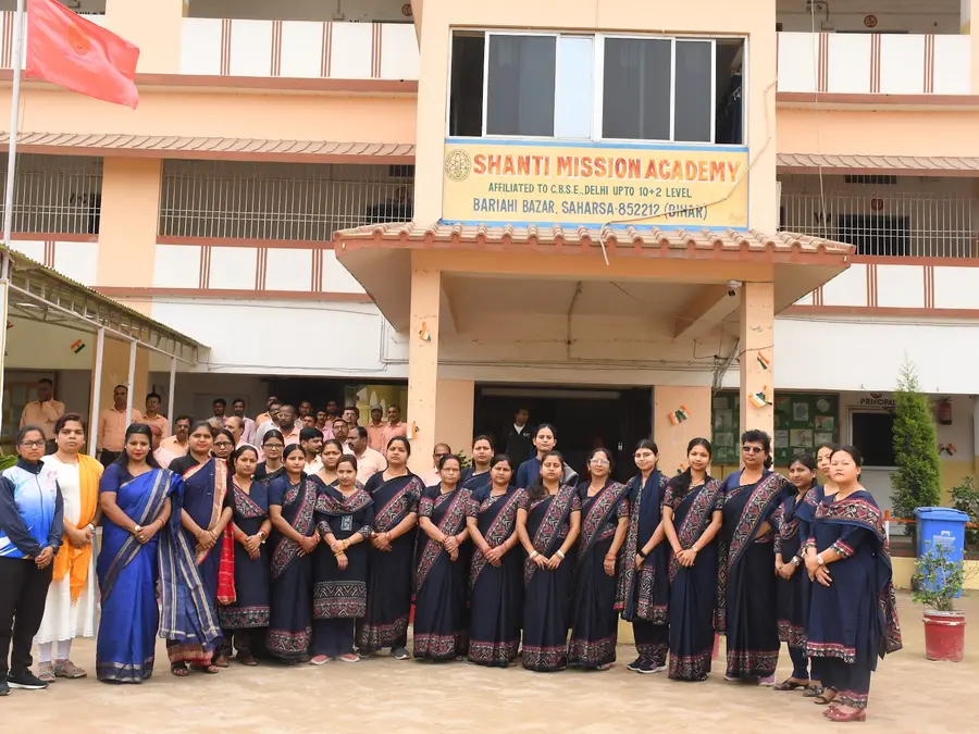 The women teachers in front of the school