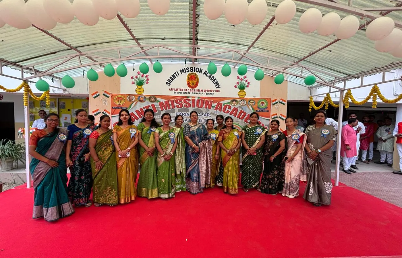 The women teachers before the school banner